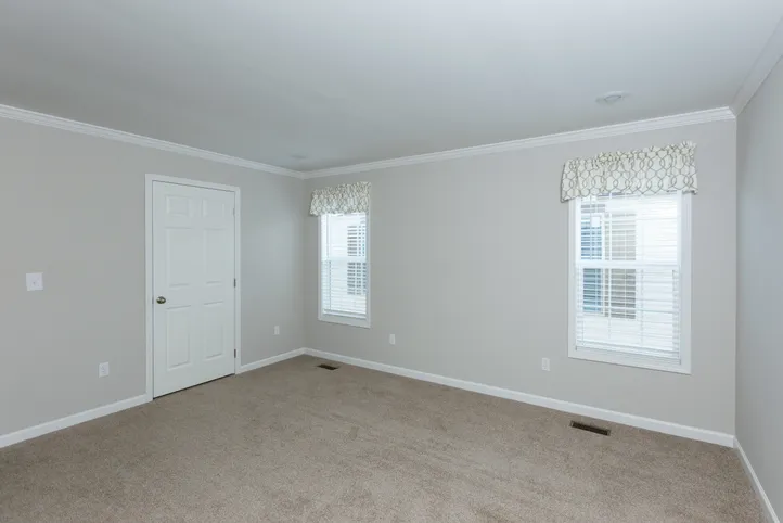 The THE FREEDOM BREEZE Primary Bedroom. This Manufactured Mobile Home features 3 bedrooms and 2 baths.