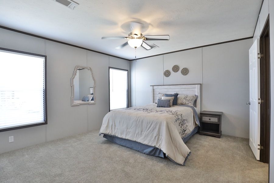 The BREEZE FARMHOUSE Primary Bedroom. This Manufactured Mobile Home features 3 bedrooms and 2 baths.
