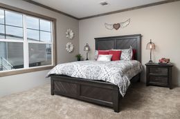 The FARMHOUSE 4 Primary Bedroom. This Manufactured Mobile Home features 4 bedrooms and 2 baths.