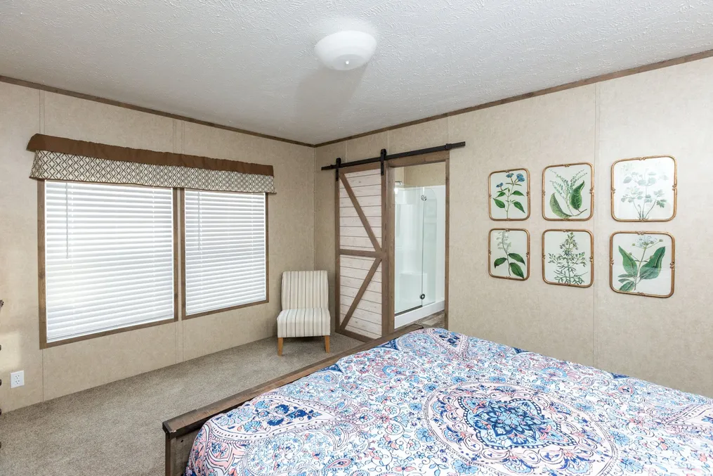 The THE RANCH HOUSE Primary Bedroom. This Manufactured Mobile Home features 3 bedrooms and 2 baths.