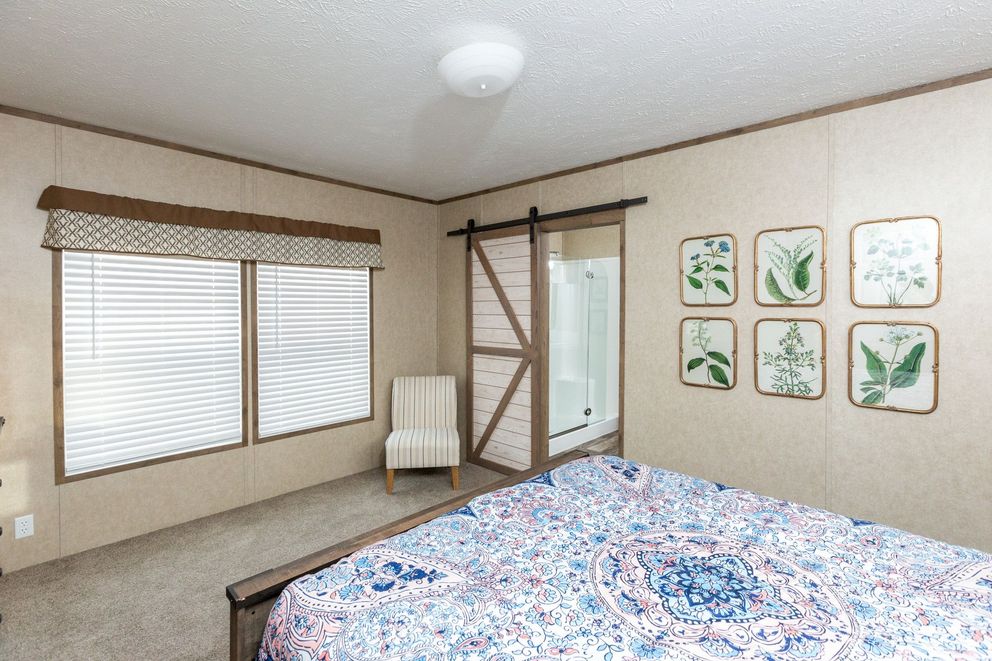 The THE RANCH HOUSE Primary Bedroom. This Manufactured Mobile Home features 3 bedrooms and 2 baths.