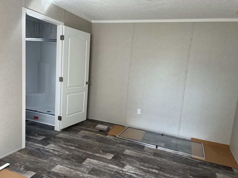 The SAPPHIRE XL 8016-644 Primary Bedroom. This Manufactured Mobile Home features 3 bedrooms and 2 baths.