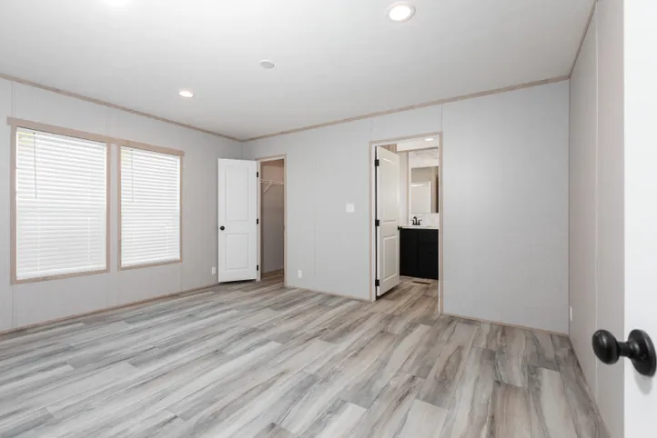 The THE ANNIVERSARY ISLANDER Primary Bedroom. This Manufactured Mobile Home features 3 bedrooms and 2 baths.