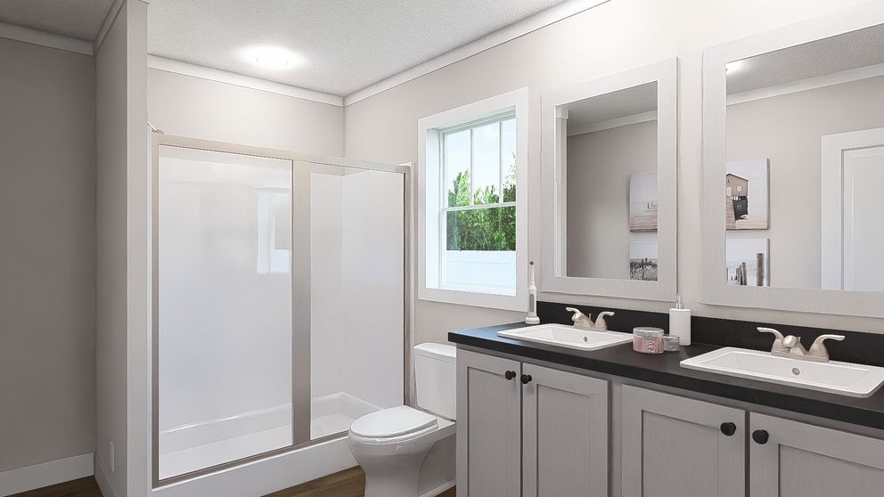 The THREE LITTLE BIRDS Primary Bathroom. This Manufactured Mobile Home features 3 bedrooms and 2 baths.