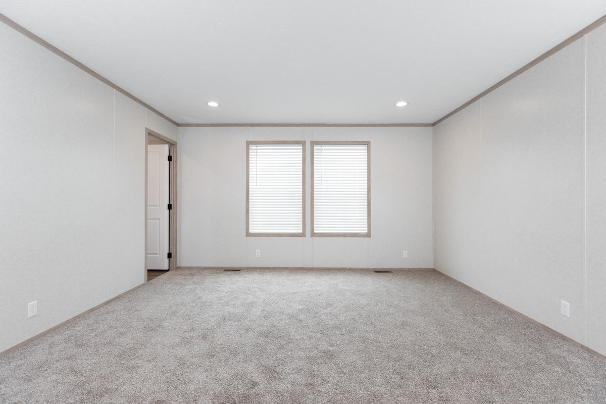 The 6032-5700 THE PULSE Primary Bedroom. This Manufactured Mobile Home features 3 bedrooms and 2 baths.