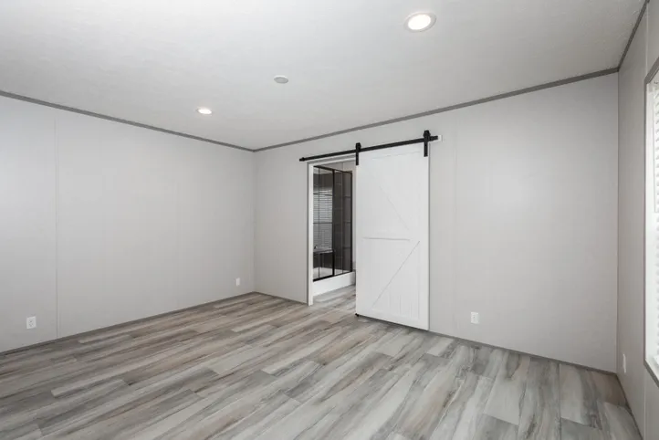 The PLATINUM ANNIVERSARY Primary Bedroom. This Manufactured Mobile Home features 3 bedrooms and 2 baths.