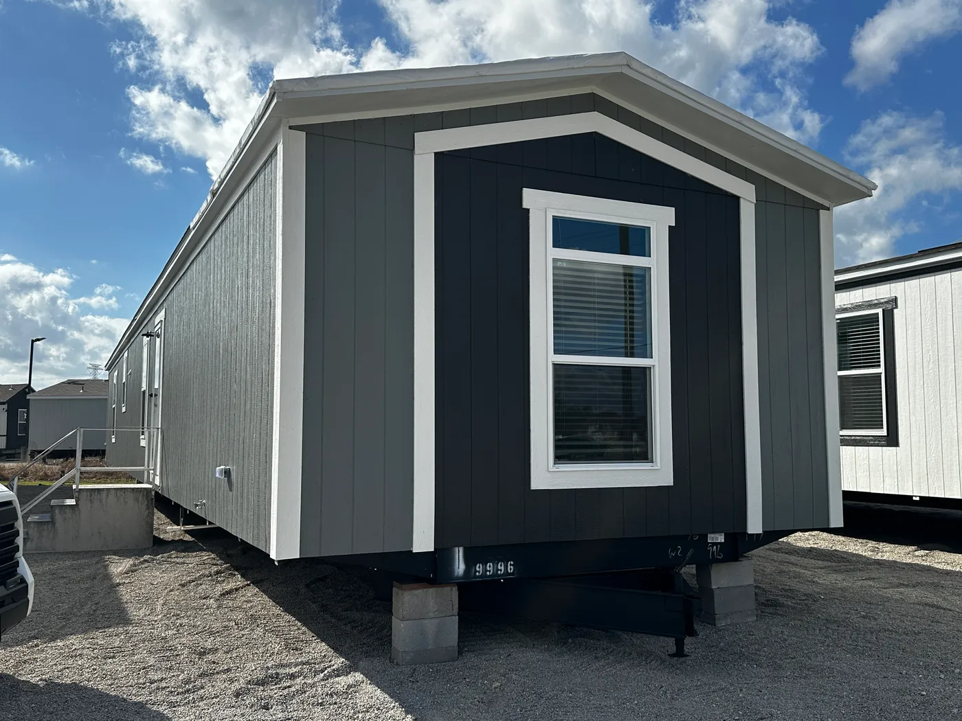 Beautiful 3 bedroom, 2 bathroom manufactured home featuring a modern charcoal interior and open-concept design. The stylish kitchen includes stainless steel appliances, a stainless steel farmhouse sink, and ample cabinet space. The spacious living room offers a built-in entertainment center with electric fireplace, perfect for relaxing or entertaining. The private primary suite features a tiled low-profile walk-in shower, a large garden soaking tub, and generous storage. This home combines affor