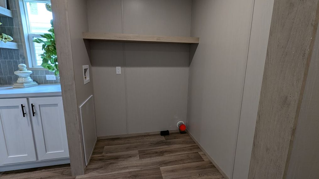 Laundry area with storage shelf.