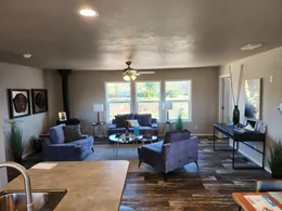 Den with wood burning fireplace and ceiling fan