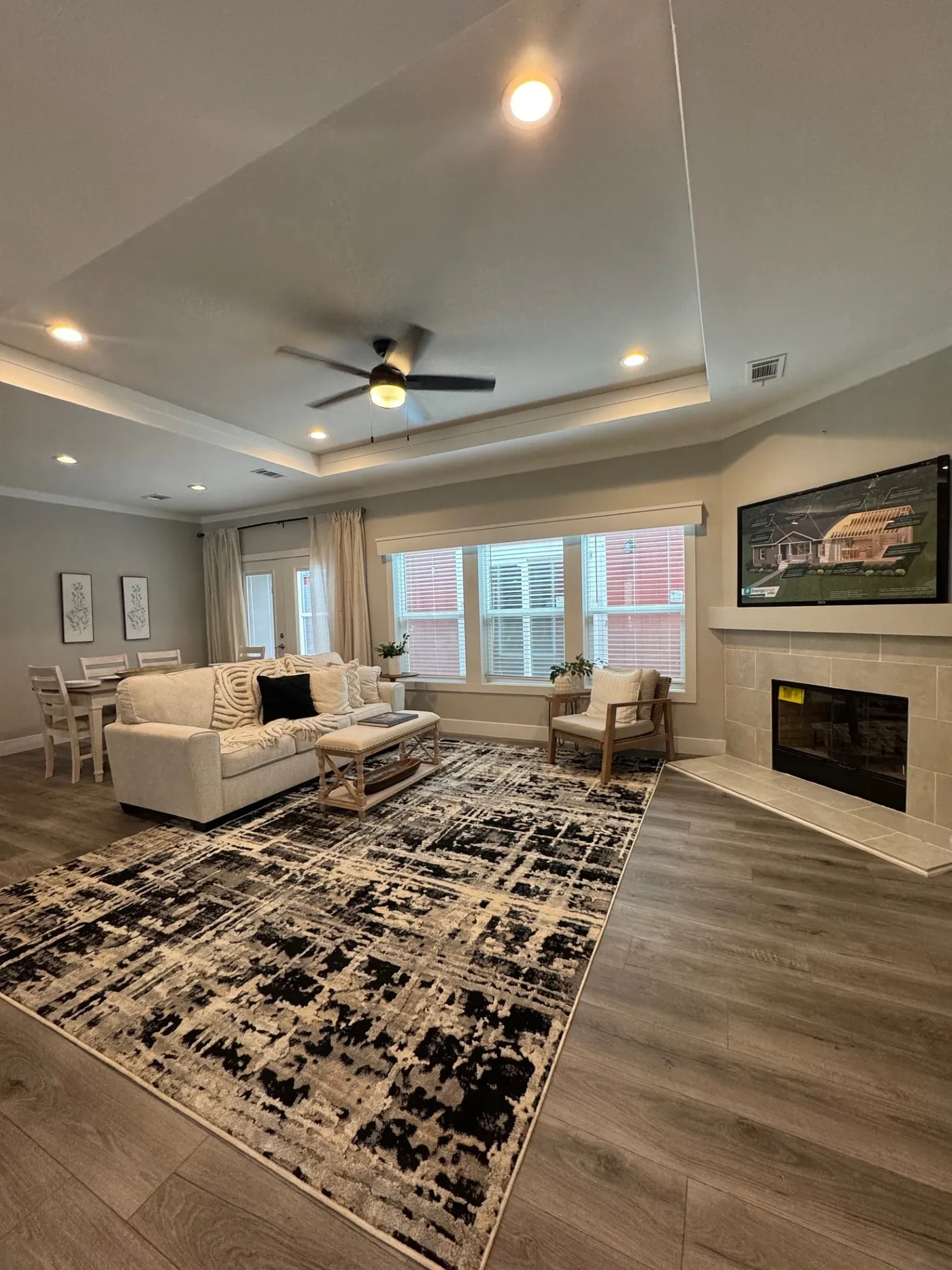 large living area with wood burning fireplace and tray ceiling