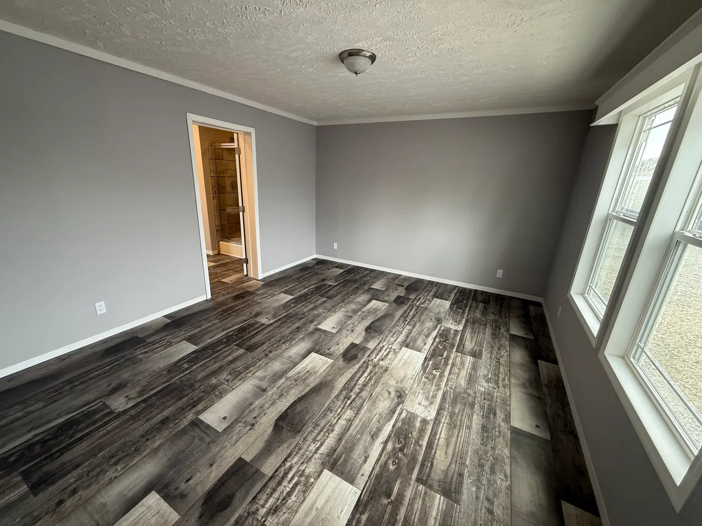 Primary bedroom with large windows and ample room for king bed