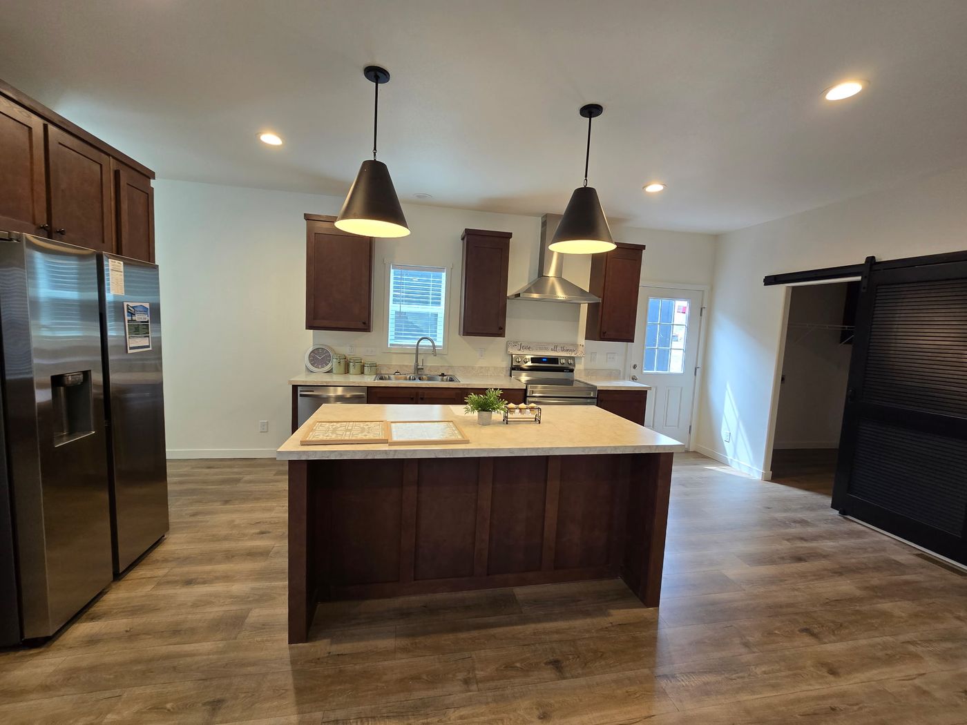 Enjoy a warm, inviting kitchen designed to feel both stylish and welcoming, centered around a large island that anchors the space. Rich, earthy tones and cozy finishes create a comfortable atmosphere, while the expansive island provides generous room for meal preparation, casual seating, and gathering with family or friends. The open layout enhances the sense of space and connection to adjacent living areas, making the kitchen ideal for everyday use and effortless entertaining. This thoughtfully