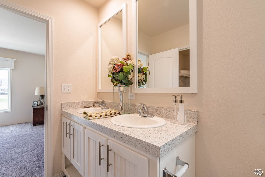 Dual framed mirrors and dual porcelain sink vanity.
