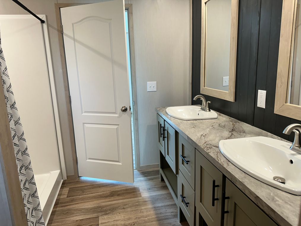 Primary bathroom with walk-in shower & dual vanity.  