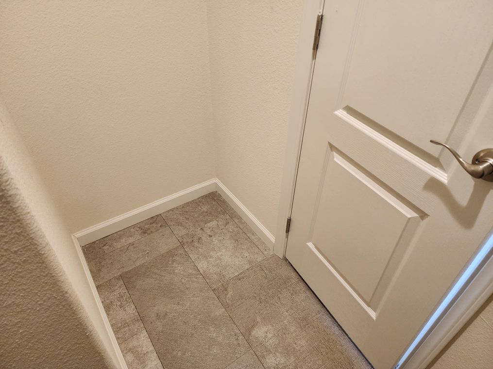 Floor space for small cabinet or dresser behind door in primary closet.