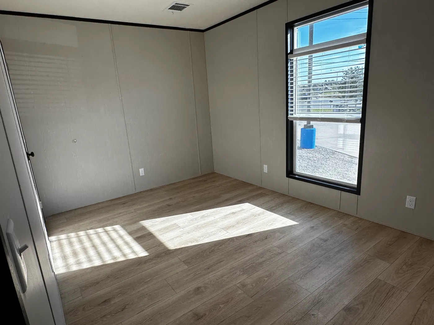 Beautiful 3 bedroom, 2 bathroom manufactured home featuring a modern charcoal interior and open-concept design. The stylish kitchen includes stainless steel appliances, a stainless steel farmhouse sink, and ample cabinet space. The spacious living room offers a built-in entertainment center with electric fireplace, perfect for relaxing or entertaining. The private primary suite features a tiled low-profile walk-in shower, a large garden soaking tub, and generous storage. This home combines affor