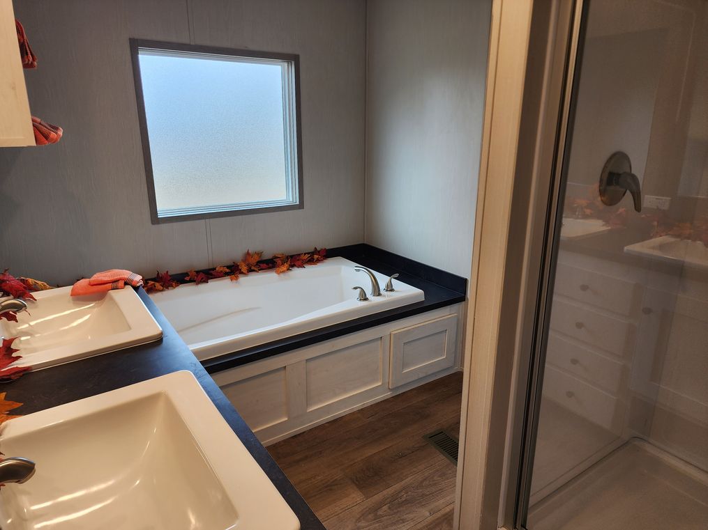Walk-in shower, deck tub and double porcelain sinks with a shelf above the tub for linens 