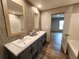 Primary bathroom with a tub/shower combo, double porcelain sinks and closet space.