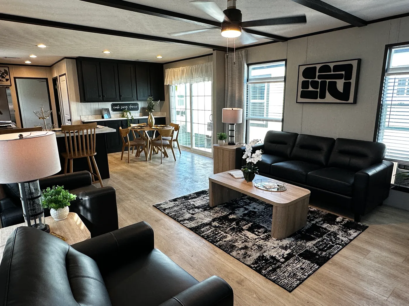 Beautiful 3 bedroom, 2 bathroom manufactured home featuring a modern charcoal interior and open-concept design. The stylish kitchen includes stainless steel appliances, a stainless steel farmhouse sink, and ample cabinet space. The spacious living room offers a built-in entertainment center with electric fireplace, perfect for relaxing or entertaining. The private primary suite features a tiled low-profile walk-in shower, a large garden soaking tub, and generous storage. This home combines affor