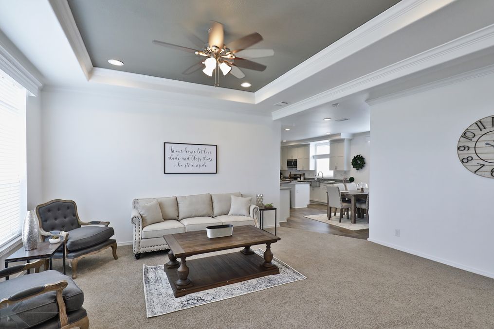 This spacious living room includes tray ceiling, crown molding and custom paint accents