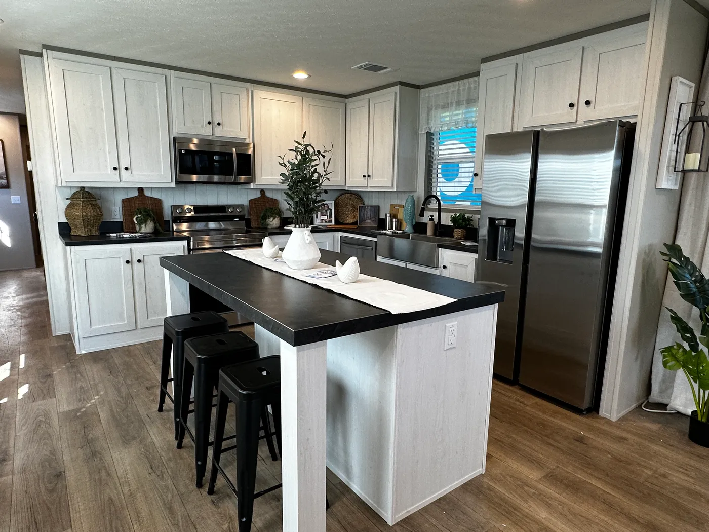 Discover this luxury porch model manufactured home featuring 2 bedrooms, 2 bathrooms, and high-end finishes designed for comfort and style. This modern manufactured home offers an open floor plan, stainless steel appliances, and a huge kitchen island perfect for entertaining. The spacious suite includes a walk-in closet and a large tiled low-profile walk-in shower for a spa-like feel. Built for durability and long-term value, this home features SmartPanel siding with a 50-year warranty, a 25-yea