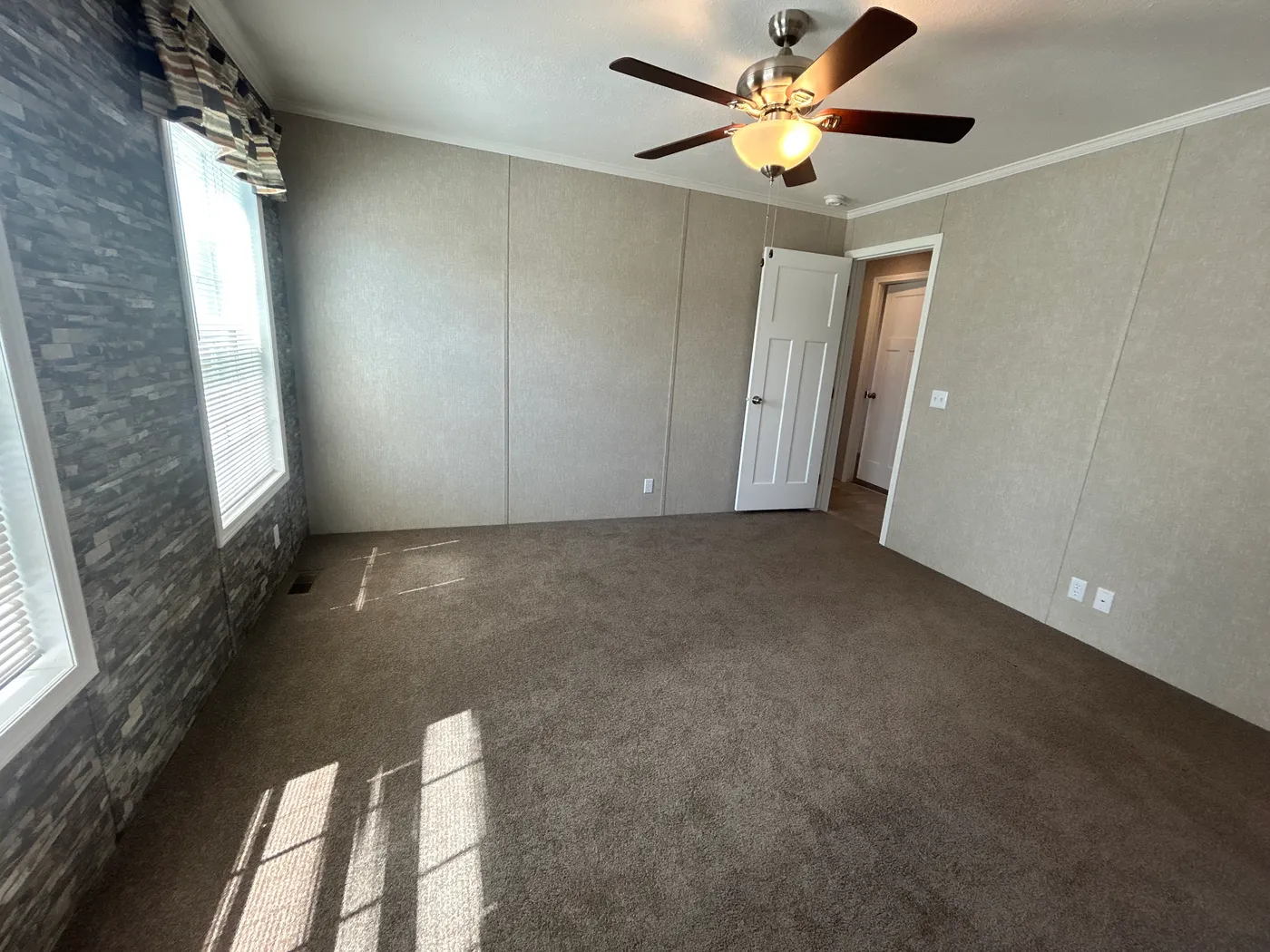 A view of the main bedroom from the main bathroom. Accent wall featured. 