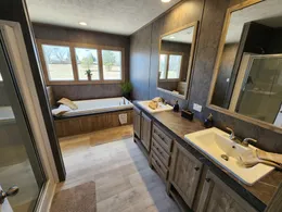 Dual porcelain sink vanity with oversized soaking tub and walk in shower lots of natural light.