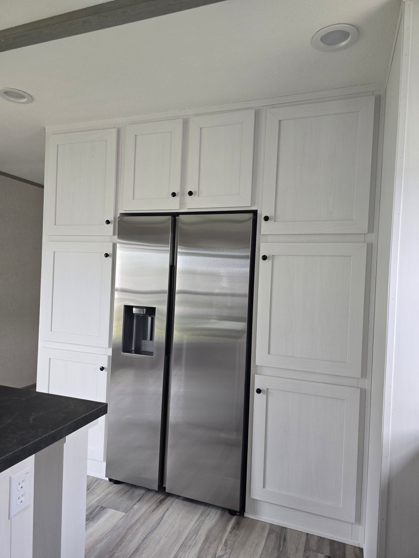 "Built in" refrigerator surrounded by pantry cabinets