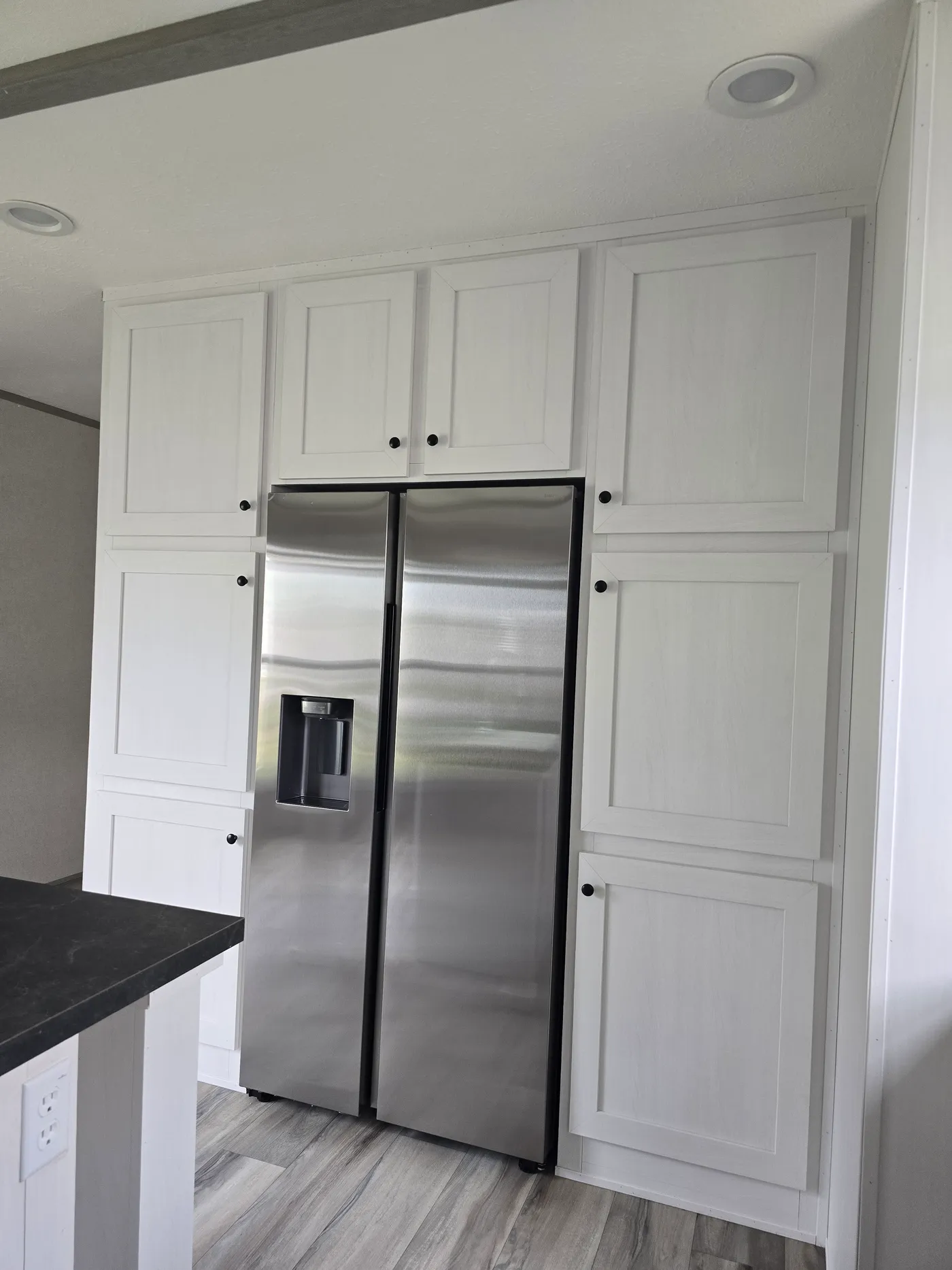 "Built in" refrigerator surrounded by pantry cabinets