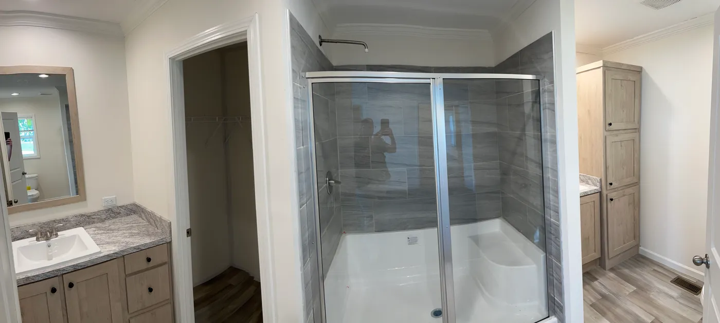 This primary bathroom has a ceramic tile shower and separate sinks.
