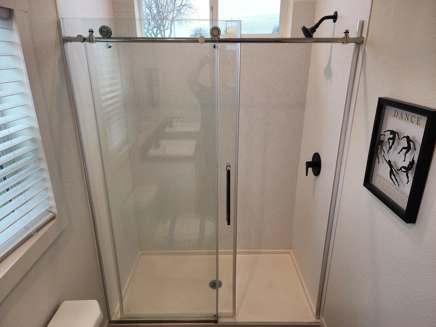 Primary walk-in shower with glass rolling door