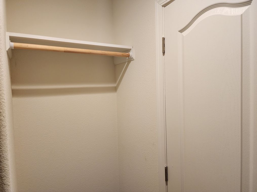 Second overhead shelf behind door of primary closet.