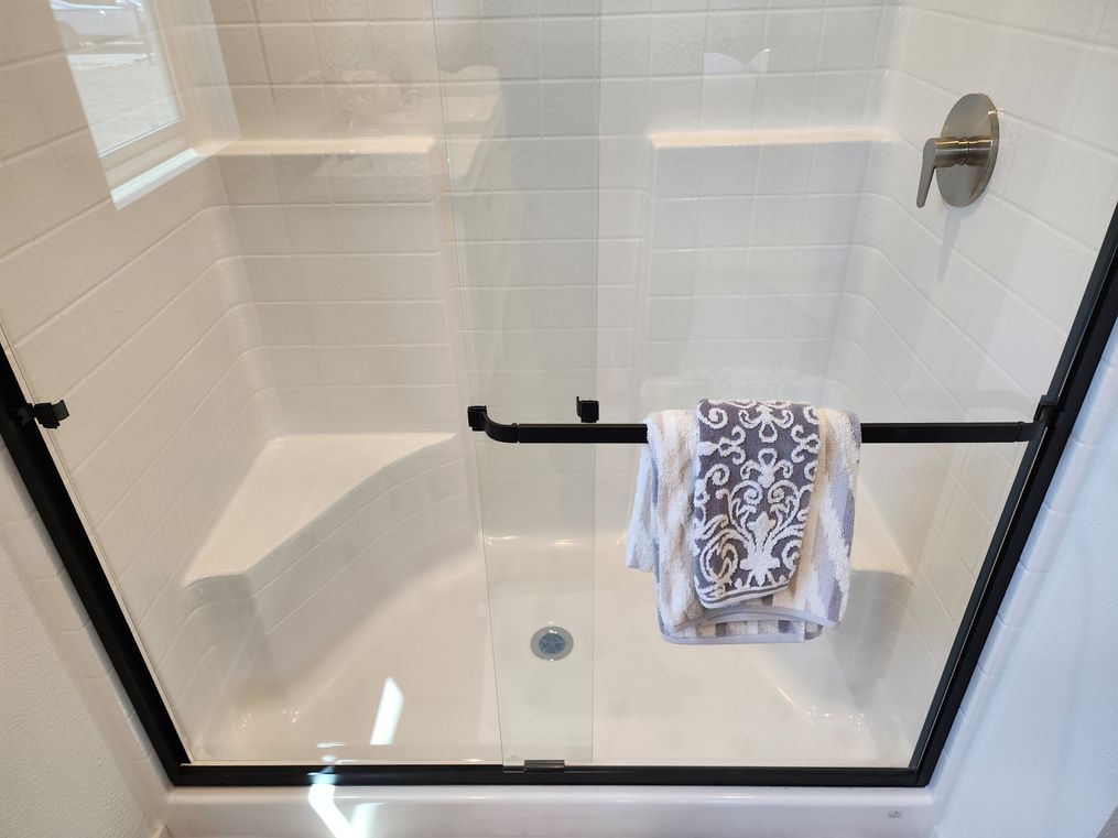 One-piece shower with sliding doors and bench seats.
