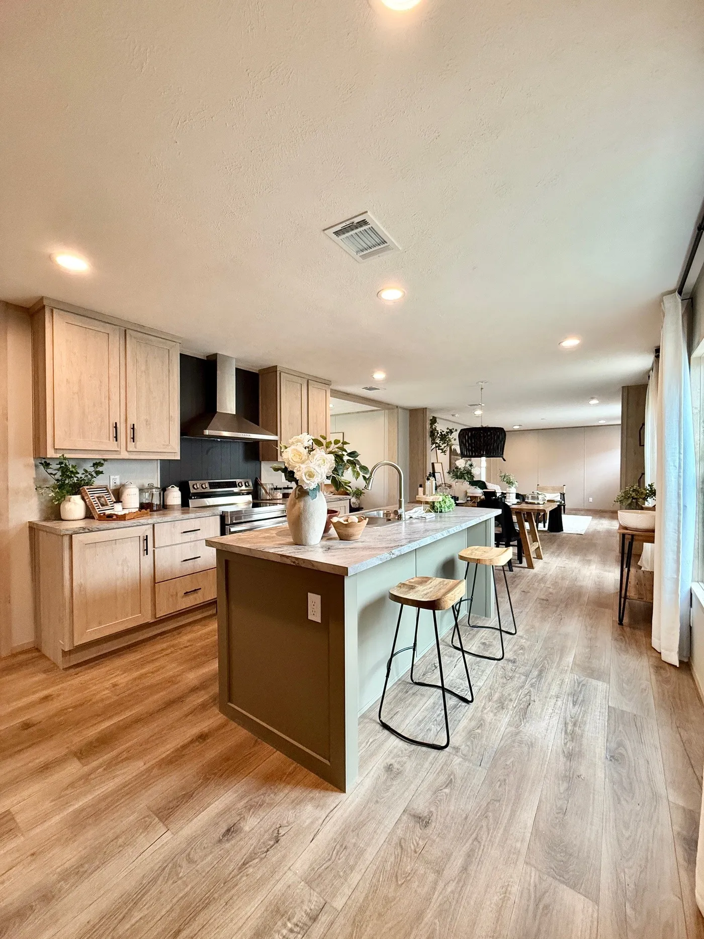 This kitchen was made for gathering.
From the oversized island with seating to the bright open layout, this space is perfect for cooking, entertaining, and making memories with family and friends.
The modern cabinets, stainless vent hood, and beautiful finishes give this kitchen a clean, designer feel —