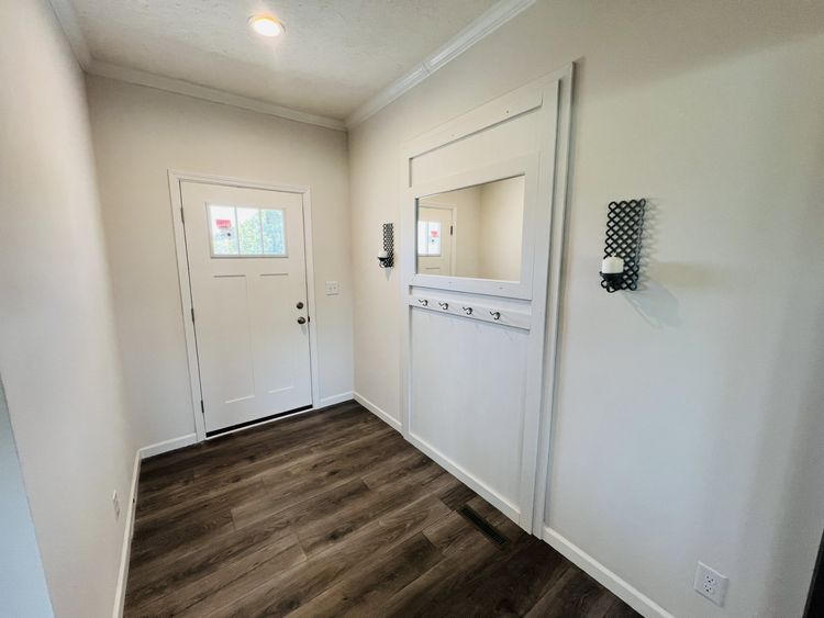 Craftsman front door, mirror and coat tree at front entry way. 