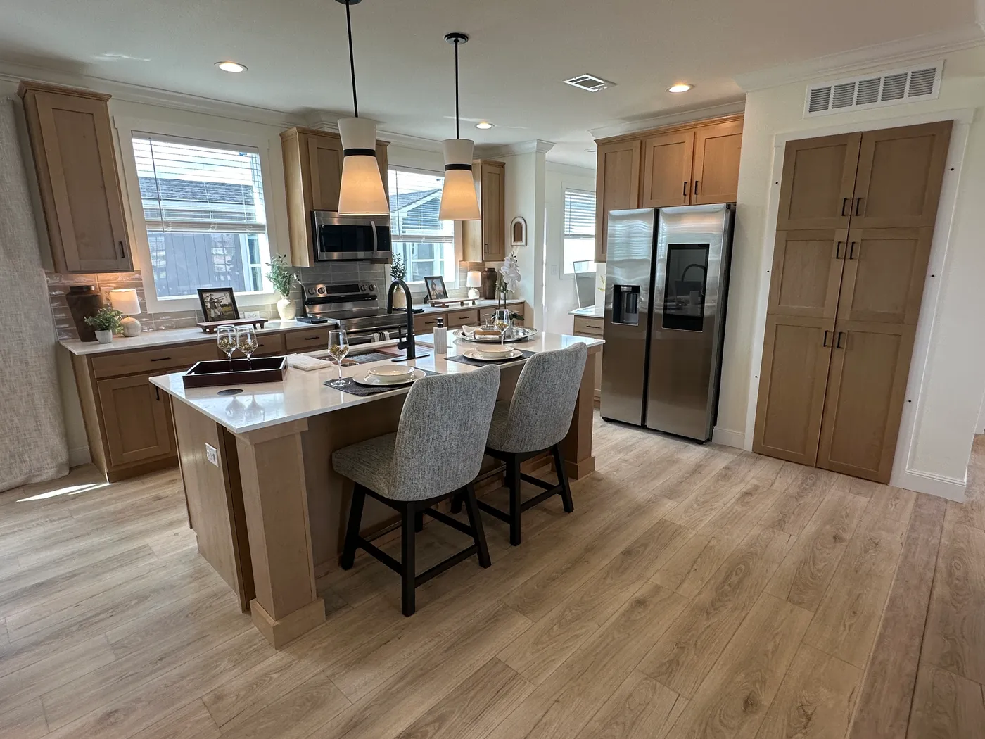 Discover The Cambridge, a stunning 3-bedroom, 2-bath luxury manufactured home at Clayton Homes of Alvin, Texas! This beautiful home features tape-and-textured walls, elegant crown molding, gorgeous quartz countertops, and a Samsung Smart Refrigerator. The gourmet kitchen includes a hidden walk-in Butler’s pantry with extra shelving and a second refrigerator for exceptional storage. The luxurious primary bedroom showcases a beautiful illuminated accent wall, while the spa-inspired primary bathroo