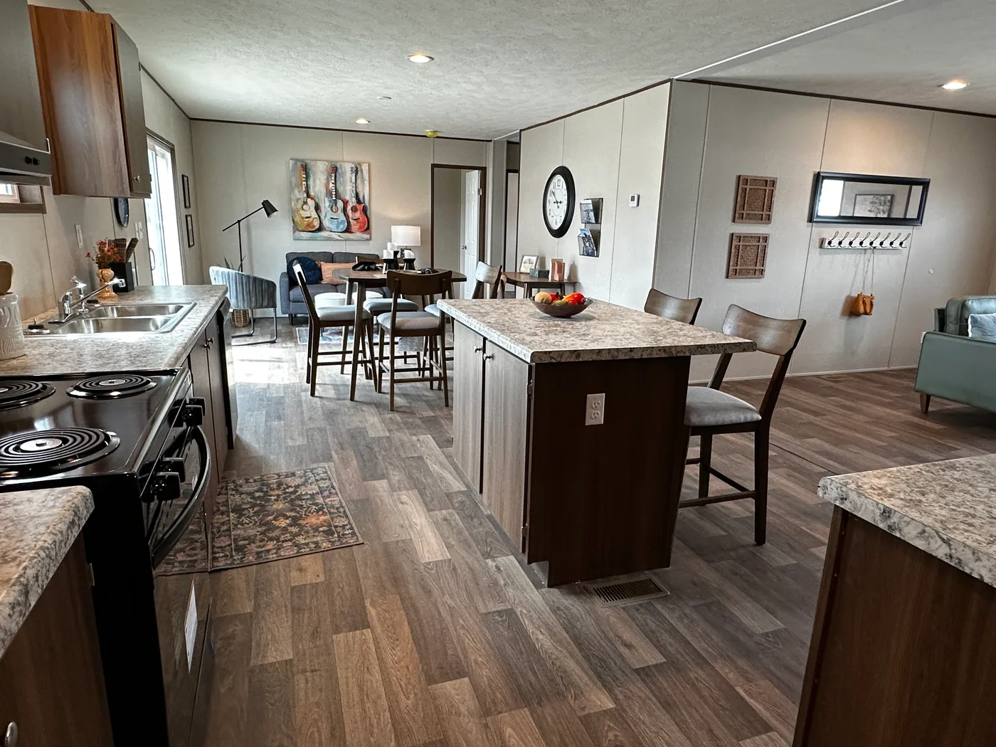 Discover the most affordable and spacious 4 bedroom, 2 bath doublewide manufactured home on the market! This budget-friendly mobile home features elevated ceilings, an open-concept layout, and plenty of room to grow with both a living room and separate den—perfect for entertaining, relaxing, or family space. The modern kitchen includes a large center island with ample storage and workspace. The private primary suite offers a walk-in closet, plus a luxury separate soaking tub and walk-in shower f