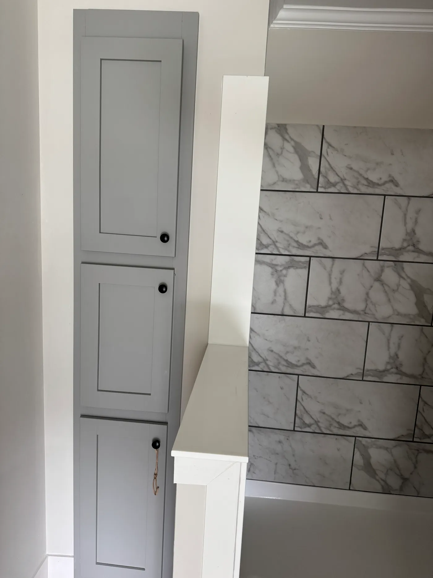 Primary bath shower with built in storage cabinets