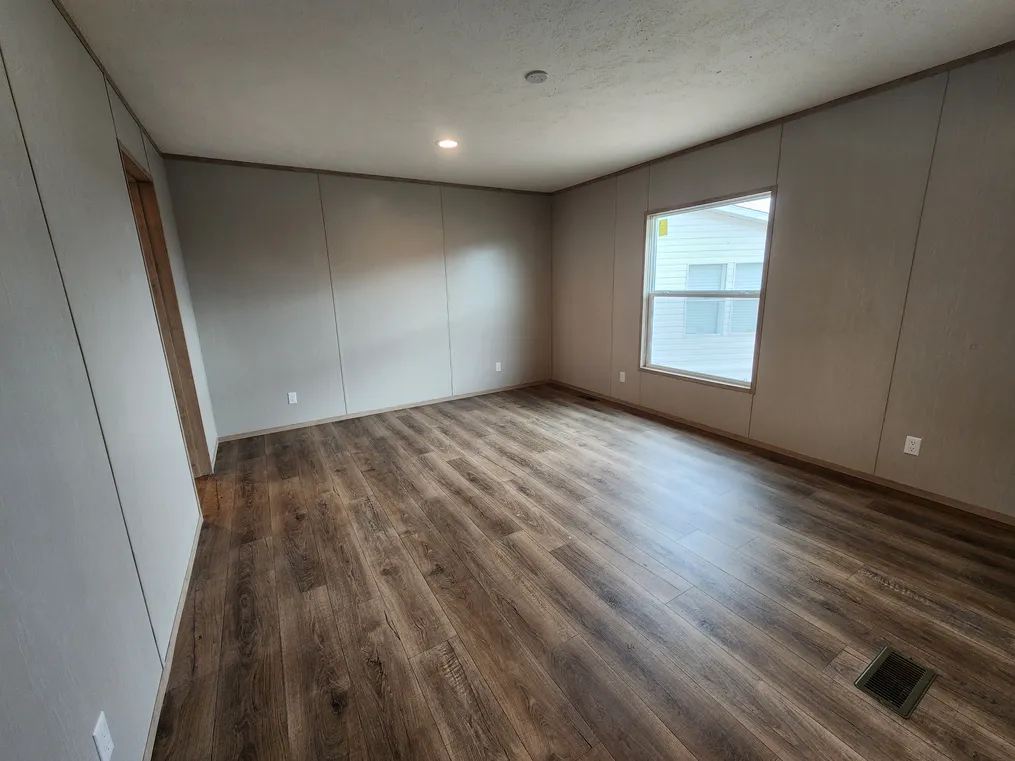 Primary bedroom with vinyl flooring and a walk-in closet