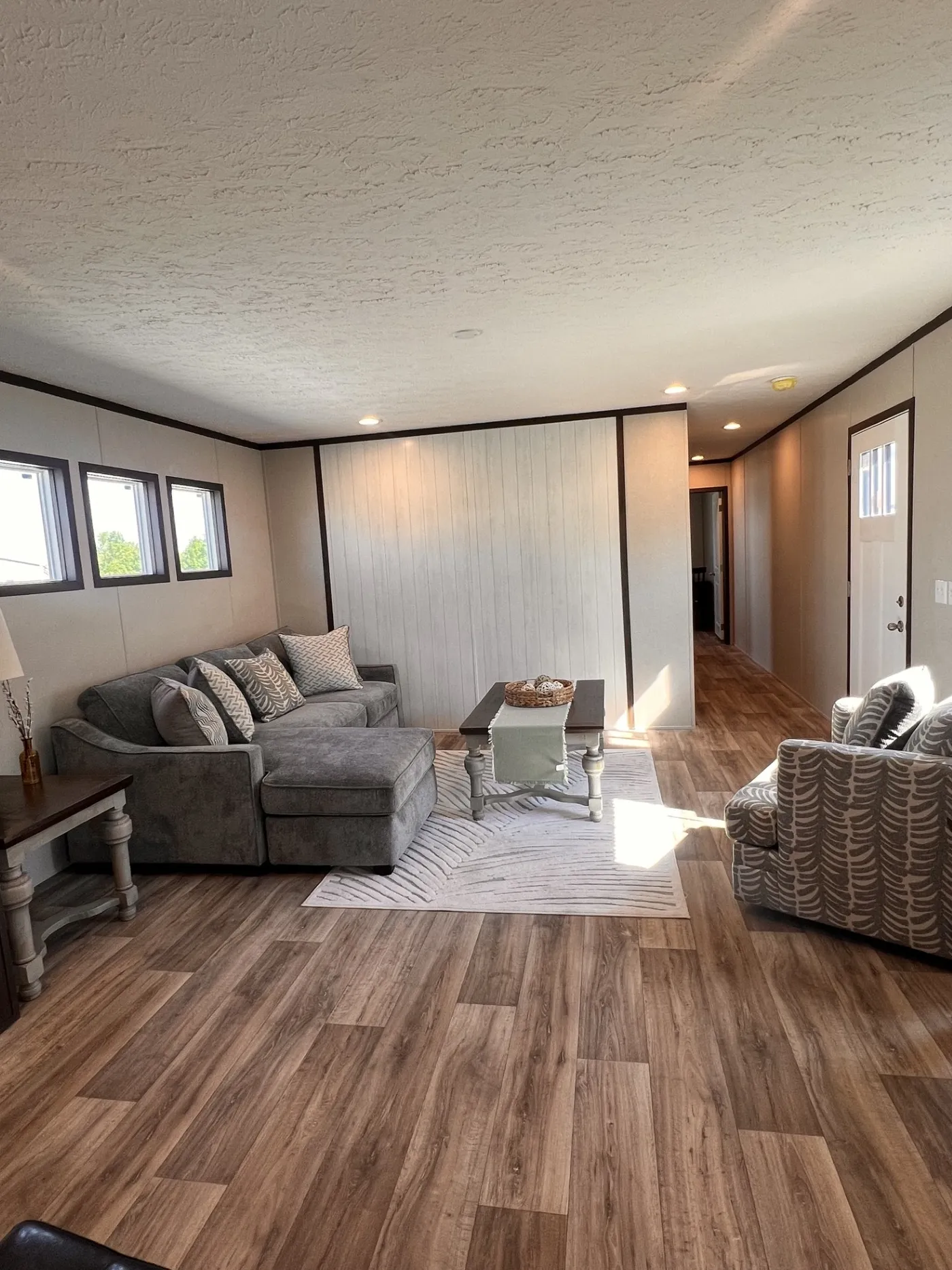 Spacious, inviting living room with warm wood flooring, plenty of natural light, and an open layout that makes the space feel bright and comfortable- perfect for relaxing or entertaining.