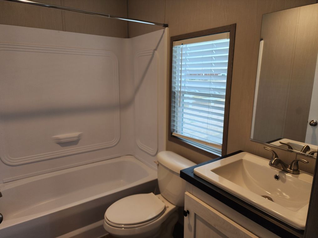 Guest bathroom with tub/shower combo and a porcelain sink