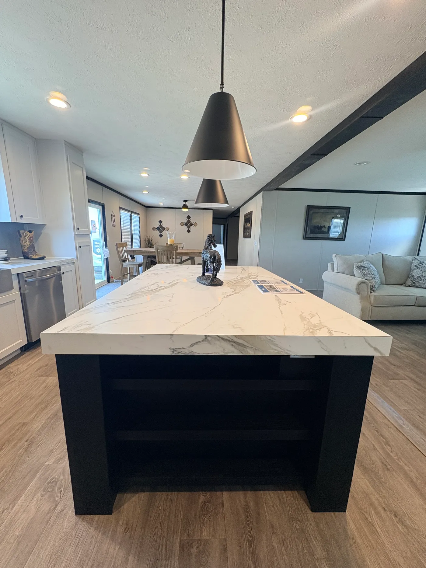 Black pendant lights over monster Island. Storage/Shelving in island