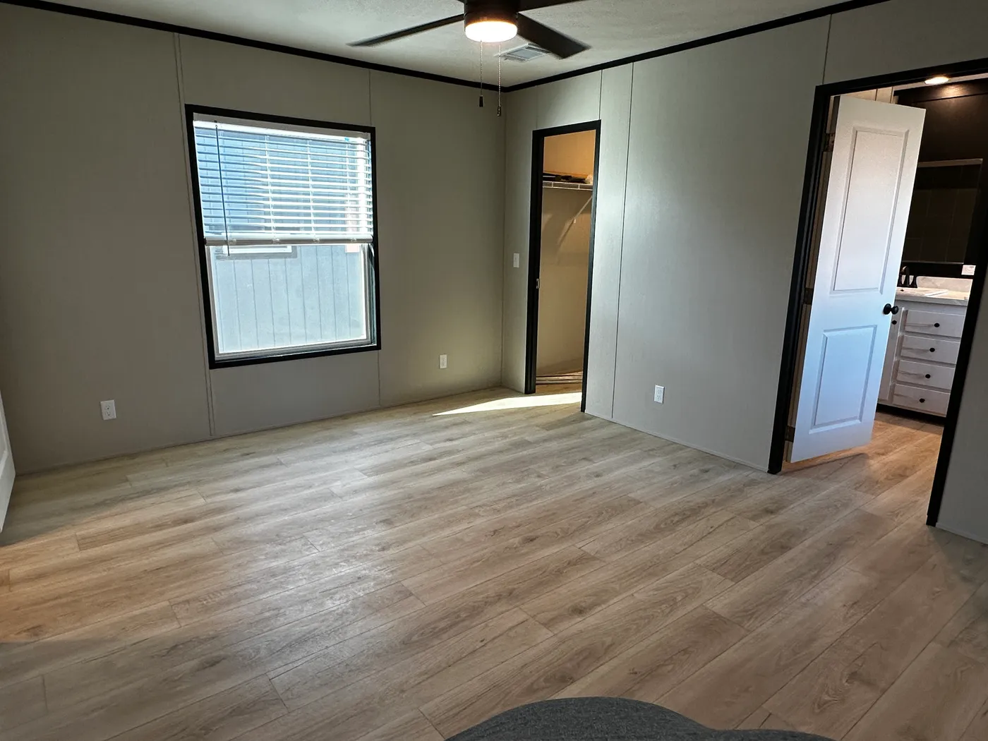 Beautiful 3 bedroom, 2 bathroom manufactured home featuring a modern charcoal interior and open-concept design. The stylish kitchen includes stainless steel appliances, a stainless steel farmhouse sink, and ample cabinet space. The spacious living room offers a built-in entertainment center with electric fireplace, perfect for relaxing or entertaining. The private primary suite features a tiled low-profile walk-in shower, a large garden soaking tub, and generous storage. This home combines affor