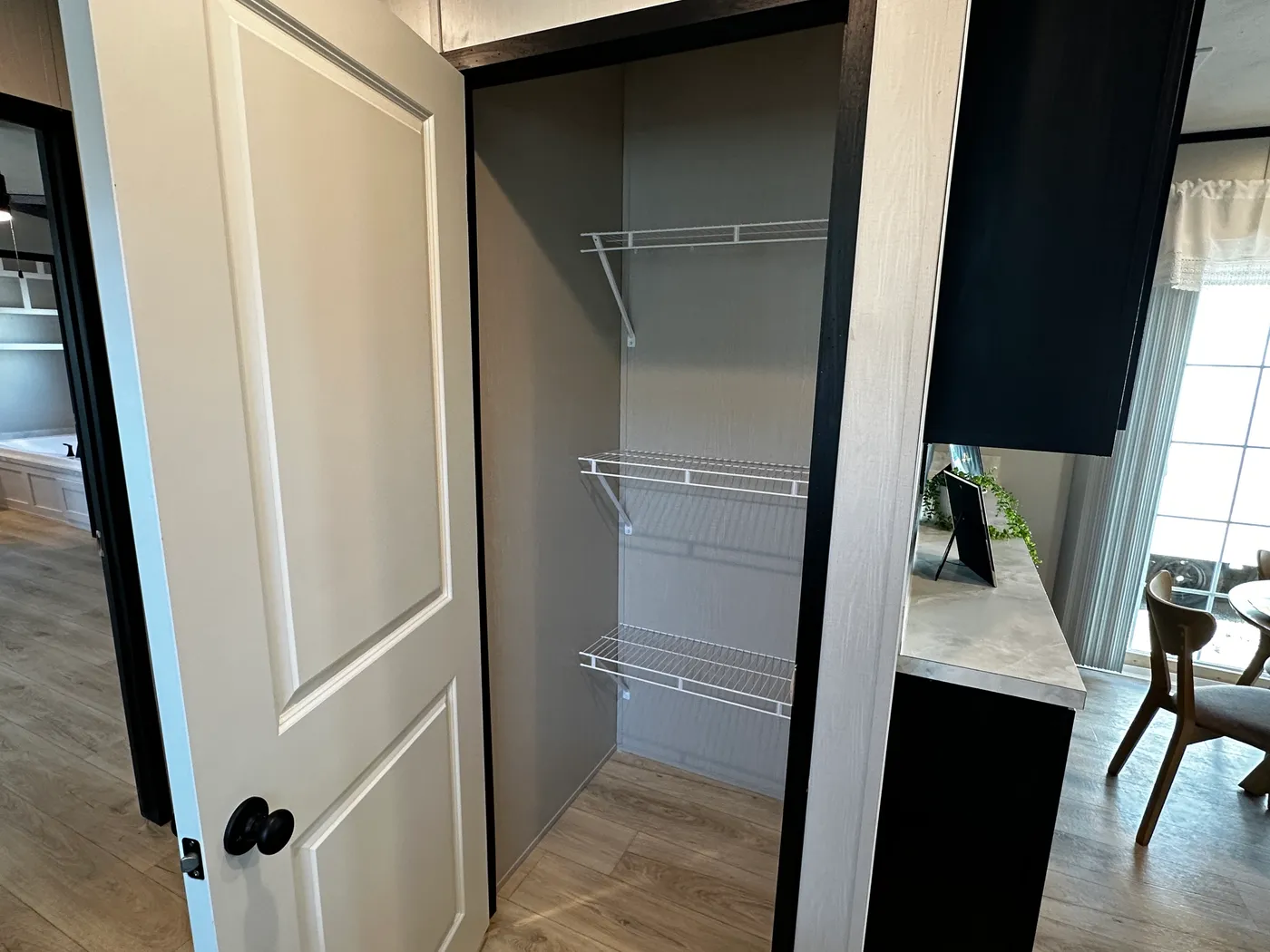 Beautiful 3 bedroom, 2 bathroom manufactured home featuring a modern charcoal interior and open-concept design. The stylish kitchen includes stainless steel appliances, a stainless steel farmhouse sink, and ample cabinet space. The spacious living room offers a built-in entertainment center with electric fireplace, perfect for relaxing or entertaining. The private primary suite features a tiled low-profile walk-in shower, a large garden soaking tub, and generous storage. This home combines affor