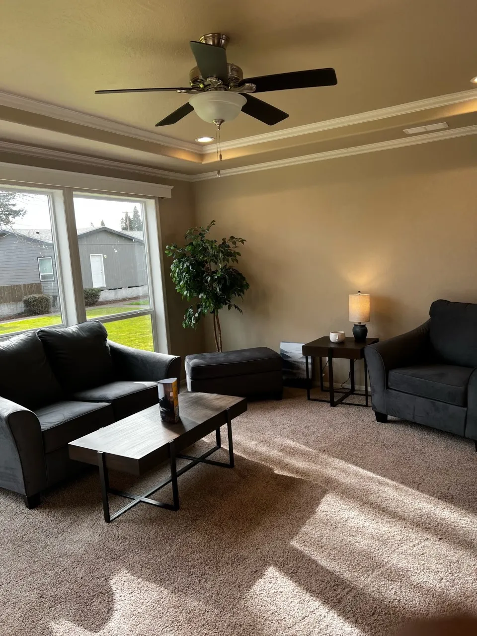 Living Room with coffer ceiling, fan and floor to ceiling windows