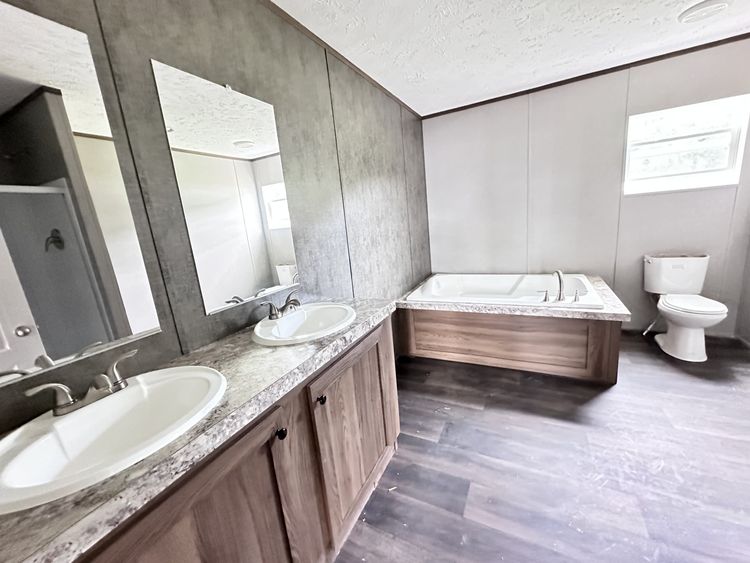 Double Vanity, Soaking Tub, and Fiberglass shower in this big Primary Bath. 