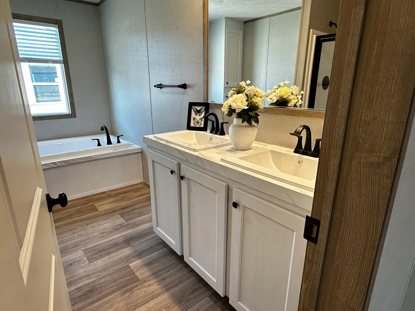 Modern luxury meets affordability in this 3 bedroom, 2 bathroom double wide manufactured home designed for comfort and style. The open-concept layout features a spacious living area with a gorgeous built-in entertainment center and plenty of natural light. The designer kitchen includes stainless steel appliances, a large kitchen island, and ample cabinet space, perfect for cooking and entertaining. Enjoy enhanced comfort with energy-efficient upflow ceiling vents for improved airflow throughout 