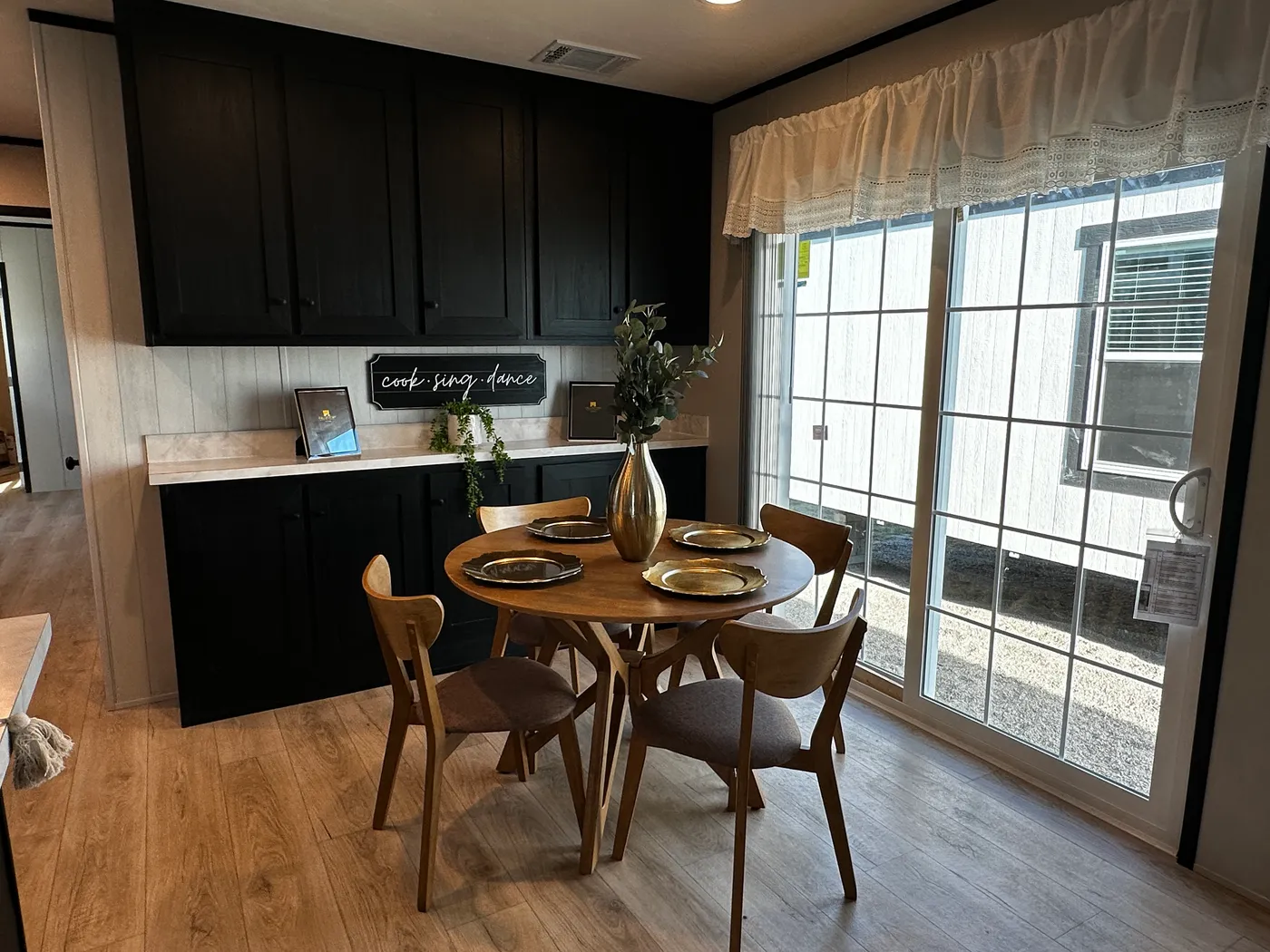 Beautiful 3 bedroom, 2 bathroom manufactured home featuring a modern charcoal interior and open-concept design. The stylish kitchen includes stainless steel appliances, a stainless steel farmhouse sink, and ample cabinet space. The spacious living room offers a built-in entertainment center with electric fireplace, perfect for relaxing or entertaining. The private primary suite features a tiled low-profile walk-in shower, a large garden soaking tub, and generous storage. This home combines affor