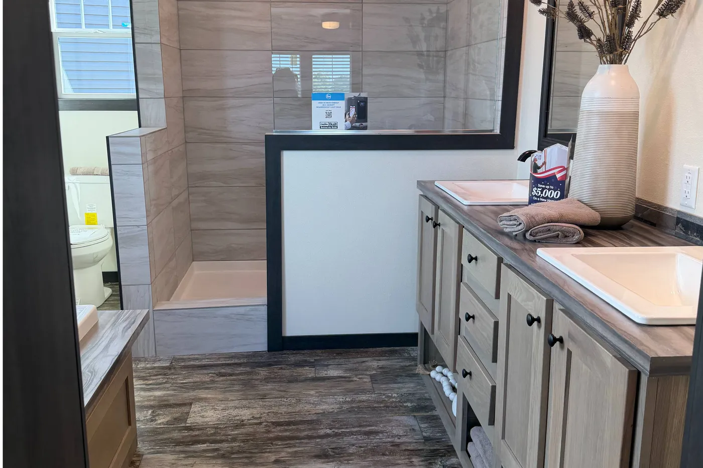 Oversized tile shower with ceramic sinks and wood cabinets. 