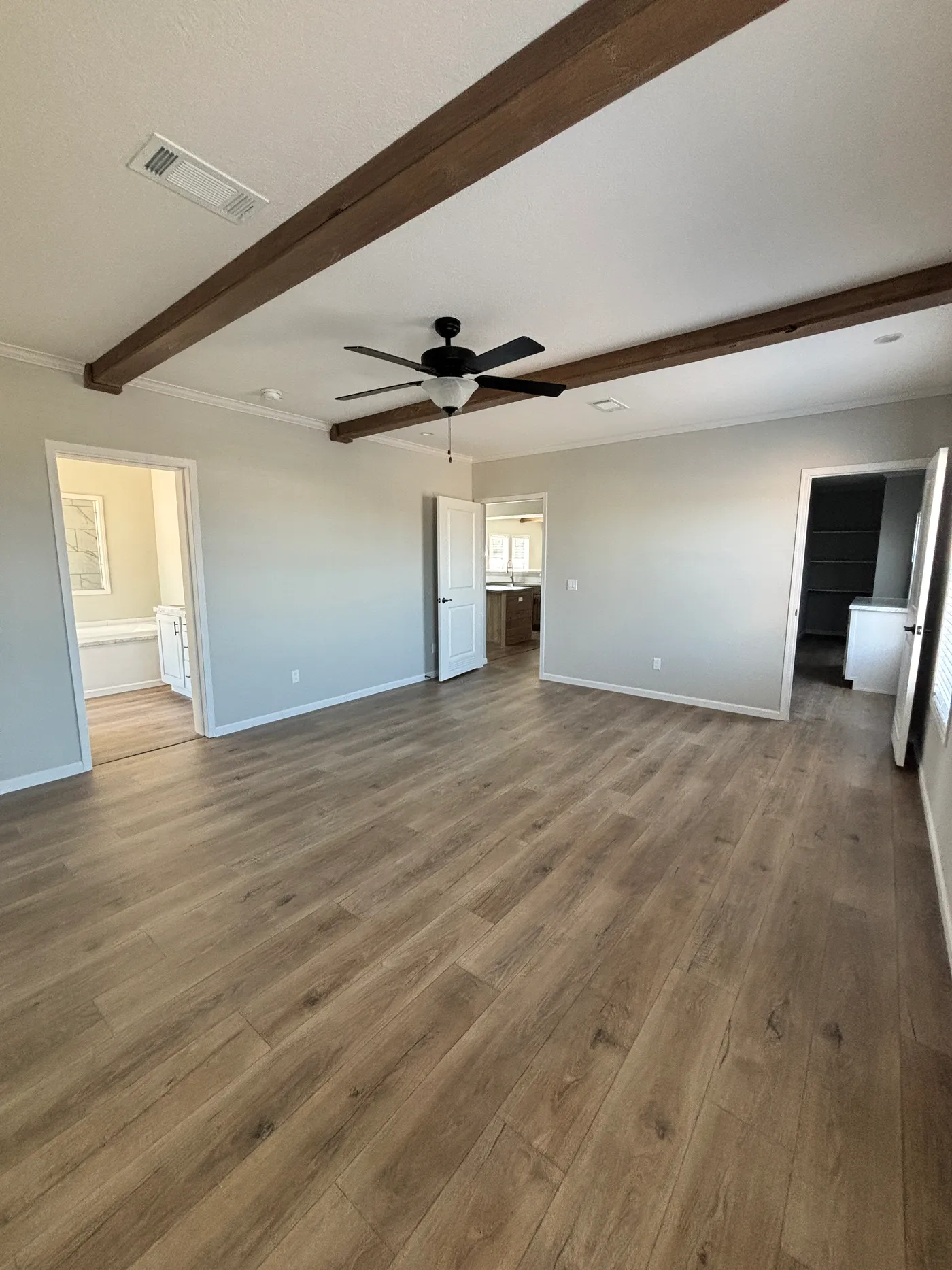 Spacious primary bedroom with ceiling beams